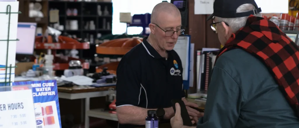 A member of the Ag Worx team serving a customer at the counter